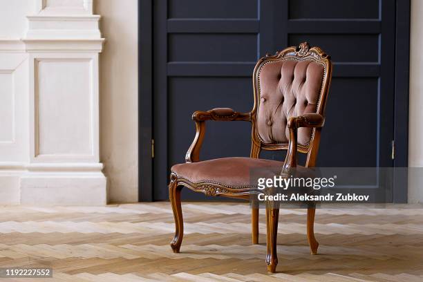 beige velour chair against the black doors in the living room. the interior of the room in retro style. - cadeira - fotografias e filmes do acervo