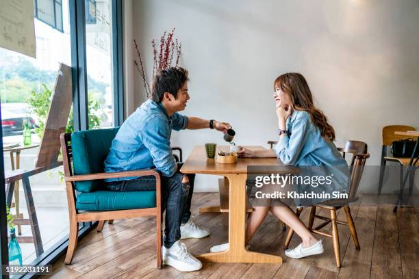 young asian couple drinking coffee at cafe coffee shop - coffee shop couple stock pictures, royalty-free photos & images