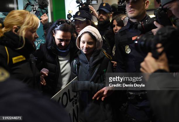 Climate change activist Greta Thunberg is escorted by police on her arrived at Chamartin train station in Madrid, on December 6, 2019. Greta is in...