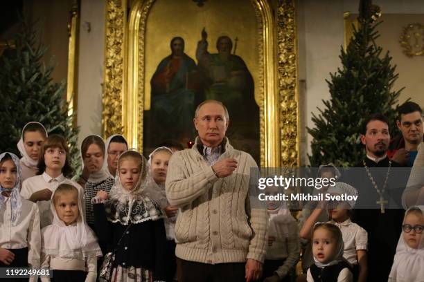Russian President Vladimir Putin crosses himself during Mass marking the Russian Orthodox Christmas at the Transfiguraton Cathedral January 7, 2020...