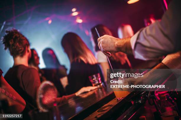 barman serving a cocktail at a bar counter during a party - cocktail counter stock pictures, royalty-free photos & images