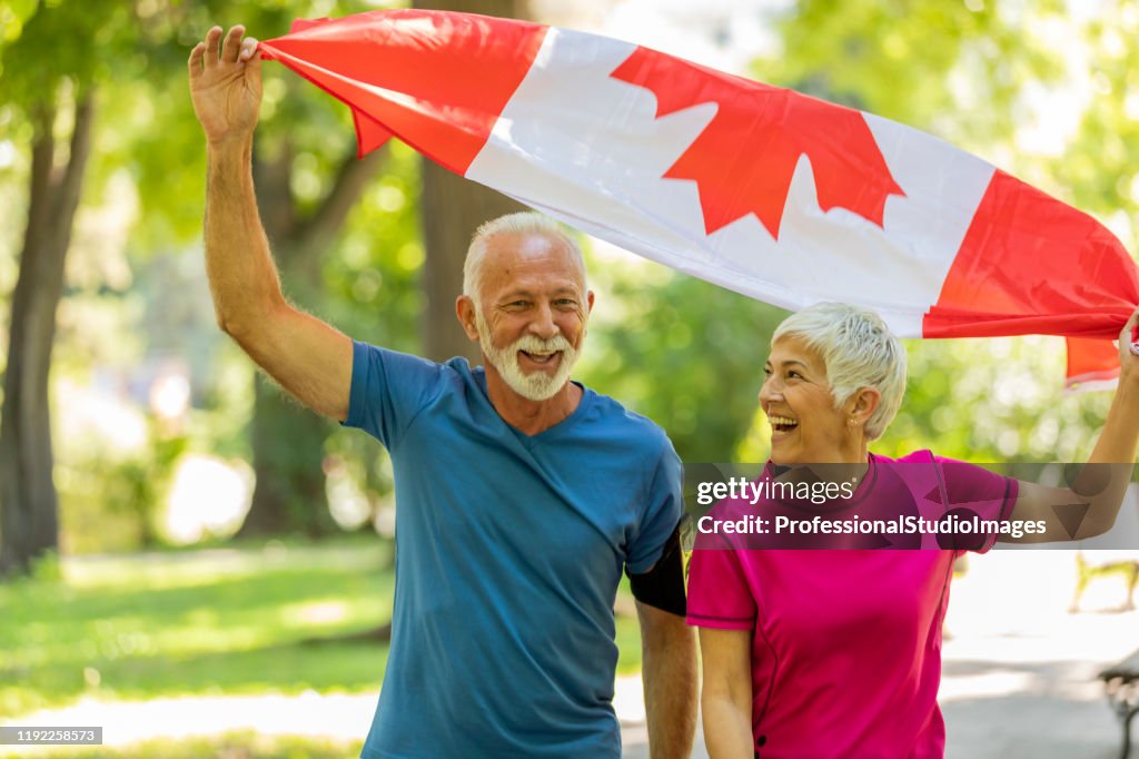 Senior Couple with Canadian Flag in Public Park