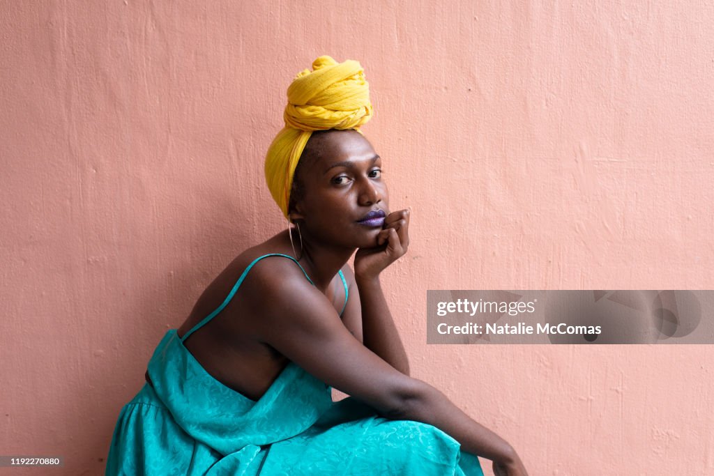 Portrait of one young woman in front of a pink wall
