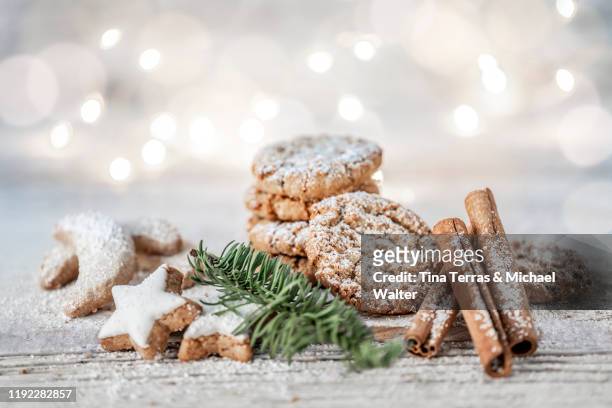 vegan oatmeal cookies with powdered sugar, cinnamon sticks and cinnamon stars on a wooden table at christmas. - cinnamon imagens e fotografias de stock