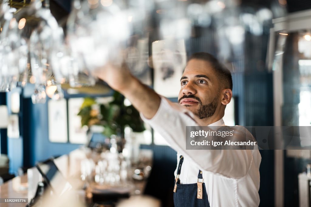 Bartender arranging wine glasses