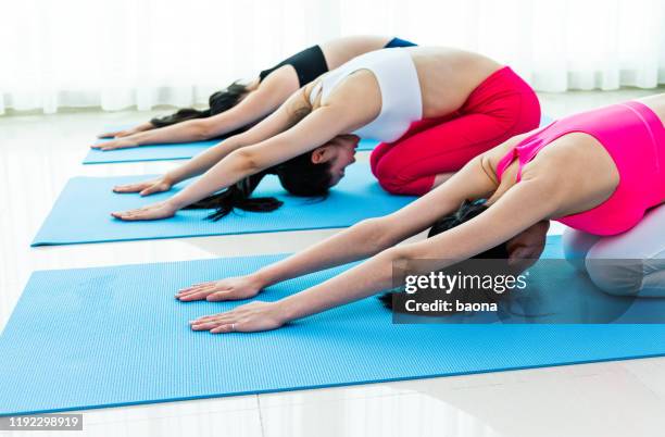 group of young women practicing child pose - hot yoga stock pictures, royalty-free photos & images