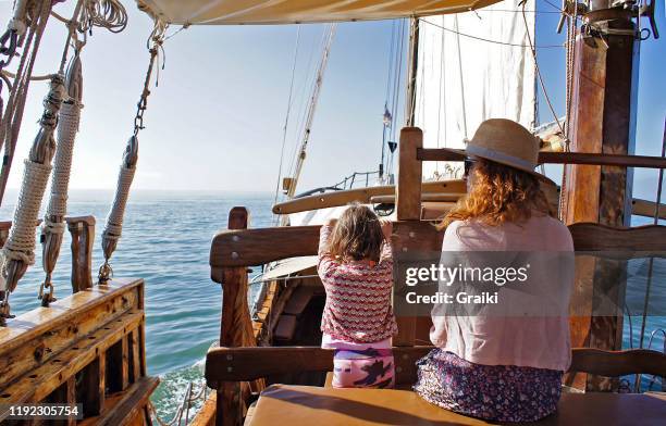 mother and daughter sailing in a tall boat. - piratenschiff stock-fotos und bilder