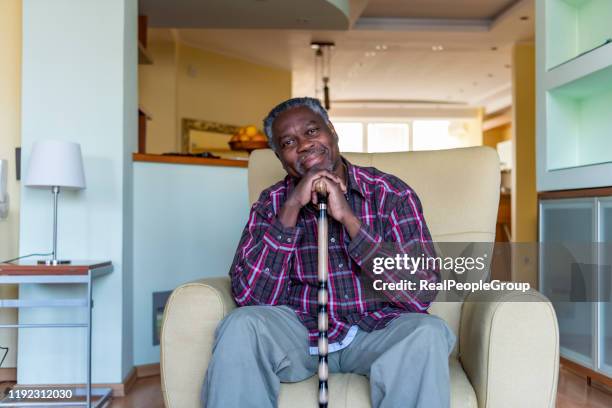 senior afro-american is relaxing in armchair at home - cane stock pictures, royalty-free photos & images