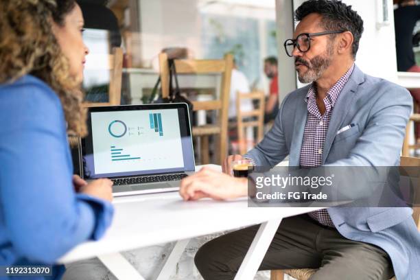 colleagues working in a cafeteria - financial decisions stock pictures, royalty-free photos & images