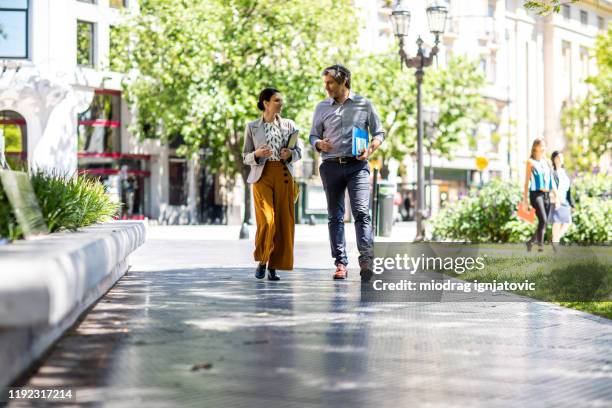 deze twee go-getters blijven onderweg - business people walking stockfoto's en -beelden