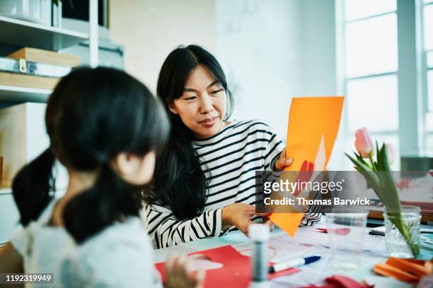 smiling mother admiring daughters handmade valentines day card - homemade valentine stock pictures, royalty-free photos & images
