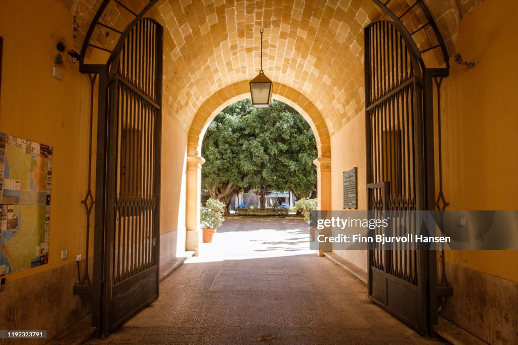 Marsala, Sicily, Italy - Ocober 17, 2019: hallway with a iron gate leading to a a park