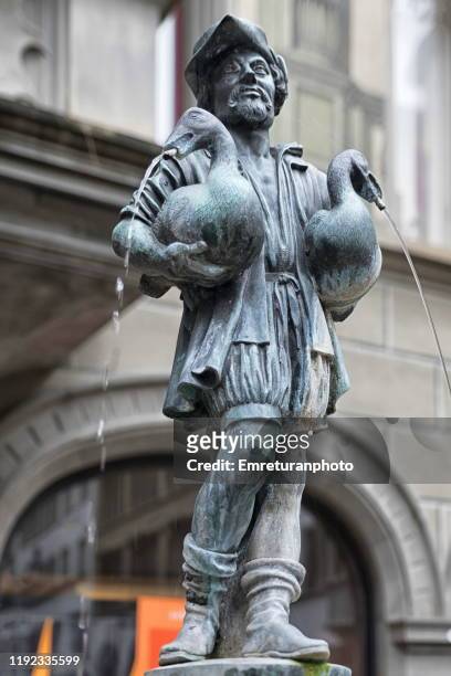 bronze man holding two geese fountain,lucerne. - emreturanphoto stock pictures, royalty-free photos & images