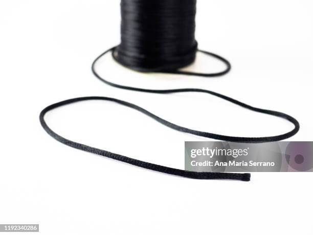spool of bright black silk thread on a white background - black lace background stock pictures, royalty-free photos & images
