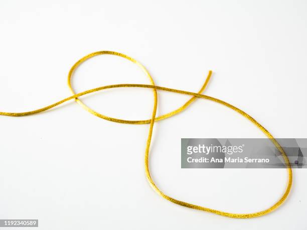 golden silk thread on a white background - lace textile stock-fotos und bilder