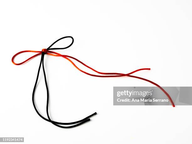 bow of bright red and black silk threads entwined on a white background - black lace background stock pictures, royalty-free photos & images