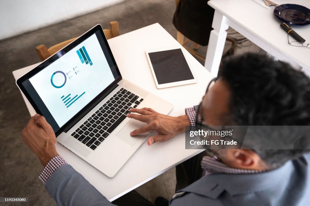 Hög vinkel syn på en affärsman som använder laptop i en restaurang