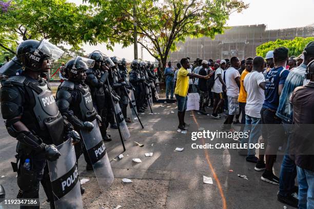 Man creates space between protesters and the police while Members of the Council of Patriots protest against the deepening economic crisis under...