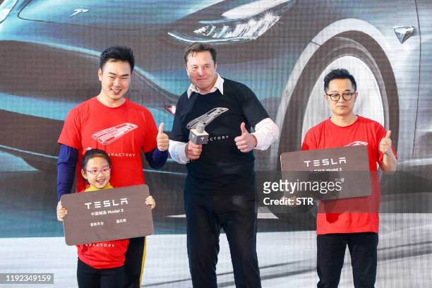 Tesla CEO Elon Musk poses for photos with buyers during the Tesla China-made Model 3 Delivery Ceremony in Shanghai. Tesla CEO Elon Musk presented the...