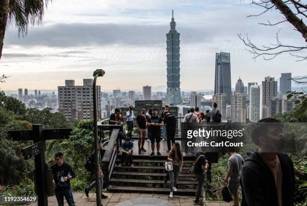 People enjoy the view of the Taipei 101 tower, once the worlds tallest building, and the Taipei skyline, from the top of Elephant Mountain on January...