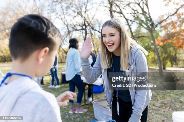 community outreach volunteer coordinator greets young volunteer - community service stock pictures, royalty-free photos & images