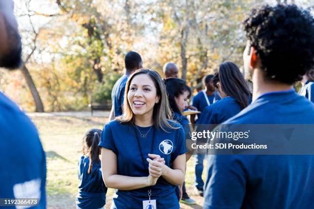 confident female volunteer talks with friends - non profit organization stock pictures, royalty-free photos & images