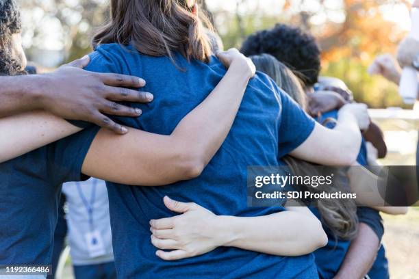 volunteers bonding during charity event - team t shirt imagens e fotografias de stock