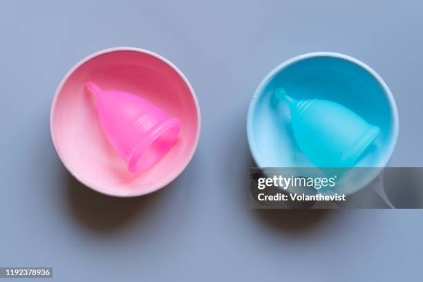 two menstrual cups in a ceramic bowl on gray backfround - menstrual cup stock pictures, royalty-free photos & images