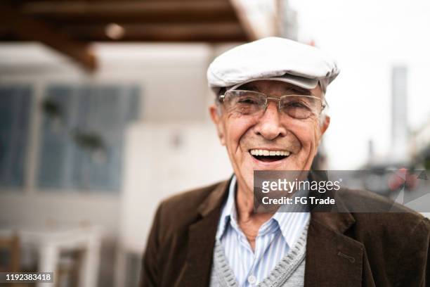 porträt eines seniors auf der straße - baskenmütze stock-fotos und bilder