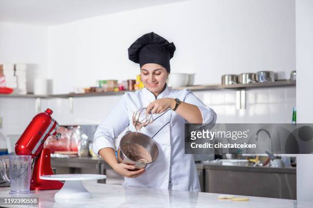 chef pâtissier féminin préparant la sauce de chocolat - chocolatier photos et images de collection