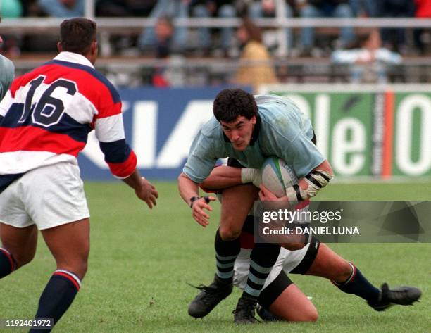 Juan Carlos Basdo de la seleccion de rugby de Uruguay intenta escapar del tackle de un no identificado rival de la seleccion de los Estados Unidos de...