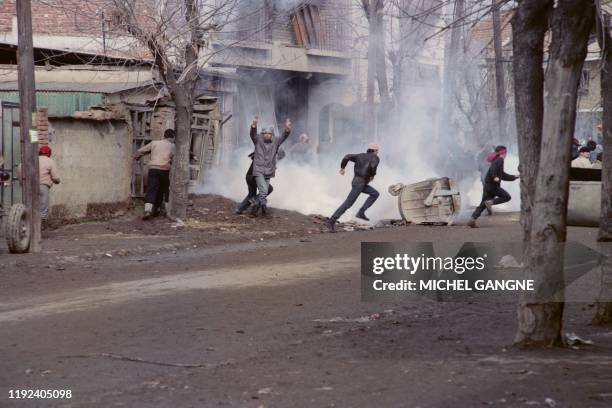 Young Albanian demonstrators return tear gas grenades to the security forces, on January 31, 1990 during a rally for democracy in the Yugoslav...