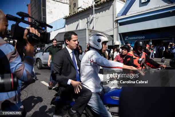 Opposition leader and reelected president of the National Assembly Juan Guaido rides on a bike to go back where busses are transporting opposition...