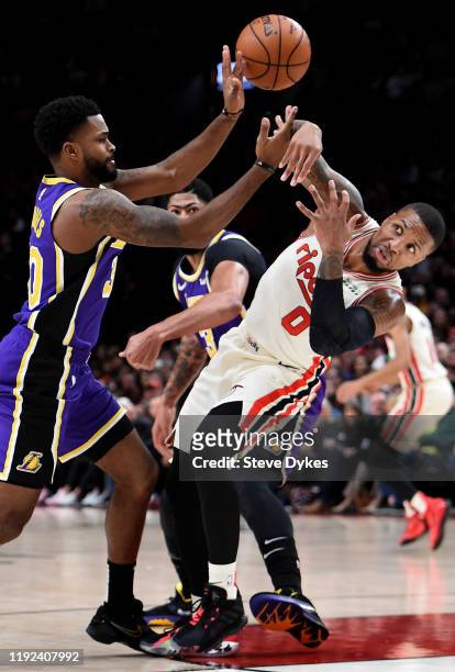 Damian Lillard of the Portland Trail Blazers battles for a loose ball with Troy Daniels of the Los Angeles Lakers during the first half of the game...