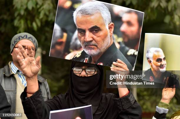 People hold placards and raise slogans during a protest against the killing of Iranian major general Qassim Soleimani, near US high commission on...