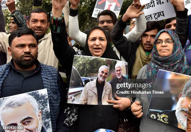 People hold placards and raise slogans during a protest against the killing of Iranian major general Qassim Soleimani, near US high commission on...