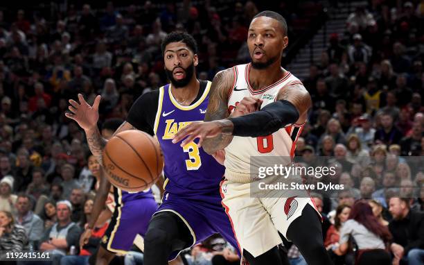 Damian Lillard of the Portland Trail Blazers passes the ball as Anthony Davis of the Los Angeles Lakers defends during the first half of the game...