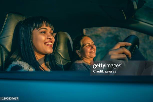 giovane donna felice alla guida di un'auto con sua madre. - winter car window foto e immagini stock