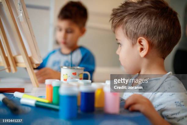petit garçon se préparant à peindre - atelier dartiste photos et images de collection