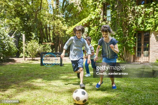 gruppe von 7-jährigen fußballern spielen in familie hinterhof - 8 ball stock-fotos und bilder