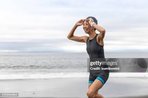 triathlete woman coming out from sea - triathlete stock pictures, royalty-free photos & images