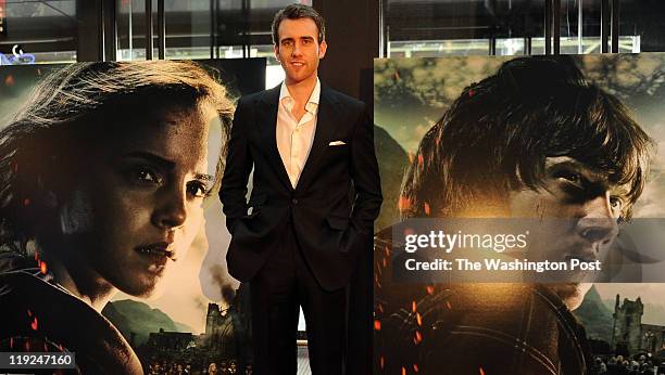 Matthew Lewis who plays Neville Longbottom poses with movie posters after arriving at the Harry Potter and The Deathly Hallows, part 2 premier in...