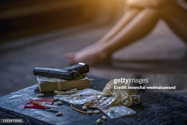 drug trafficker holding a lot of cash on hand and use gun pushing drugs to the customer in the drug dealing, concept about the drug problem - highly trafficked stock pictures, royalty-free photos & images