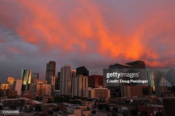 Turbulent weather produced a spectacular sunset over the skyline of the Denver downtown as seen from the stadium as the Milwaukee Brewers face the...