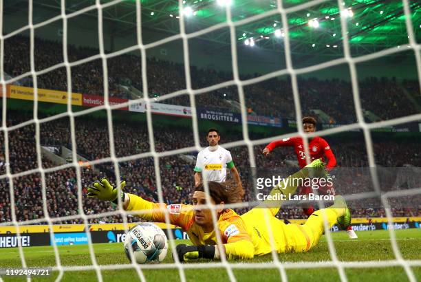 Yann Sommer of Borussia Monchengladbach dives to make a save on the line as Kingsley Coman of FC Bayern Munich reacts during the Bundesliga match...