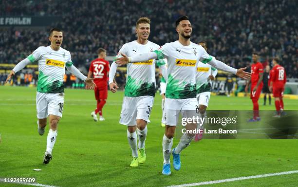 Ramy Bensebaini of Borussia Monchengladbach celebrates with Nico Elvedi and Stefan Lainer after scoring his team's first goal during the Bundesliga...