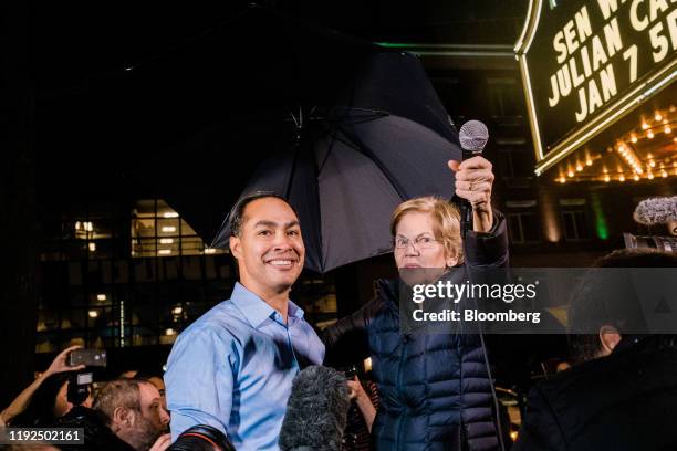 Senator Elizabeth Warren, a Democrat from Massachusetts and 2020 presidential candidate, right, holds up a microphone as Julian Castro, former...