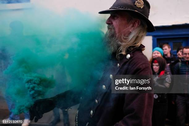 Man releases green smoke as participants walk through the streets during the annual Whitby Krampus parade on December 07, 2019 in Whitby, England....