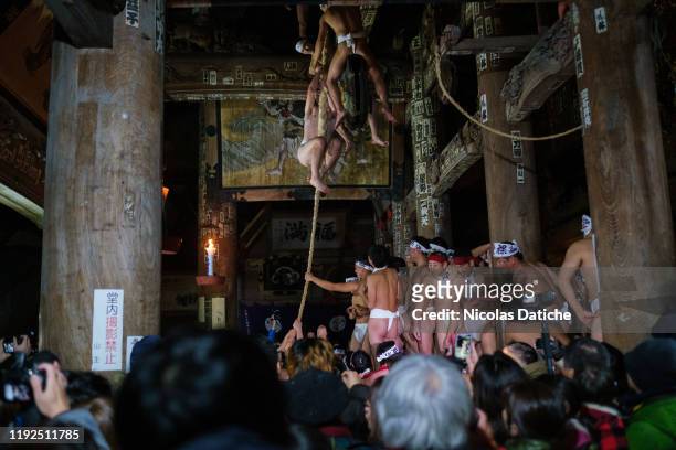 Men wearing fundoshi try to climb the rope during Yanaizu's naked man festival in Yanaizu. Every year on 7 of January, the Yanaizu Hadaka Mairi take...