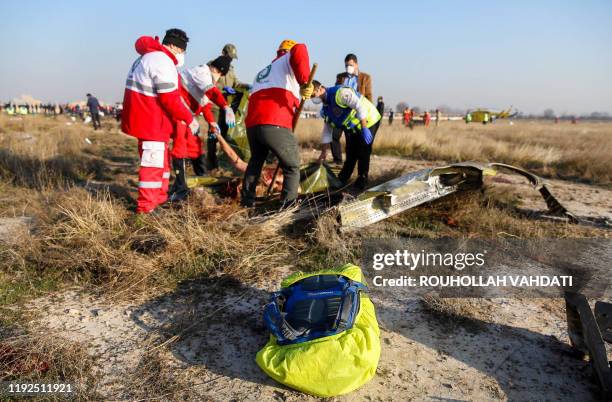 Graphic content / Rescue teams recover a body after a Ukrainian plane carrying 176 passengers crashed near Imam Khomeini airport in the Iranian...